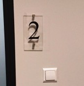 Tabliczki z numeracją pokoi z plexi na stalowych dystansach