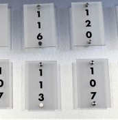 Tabliczki z numeracją pokoi z plexi na stalowych dystansach