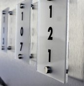 Tabliczki z numeracją pokoi z plexi na stalowych dystansach