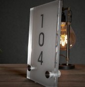 Tabliczki z numeracją pokoi z plexi na stalowych dystansach