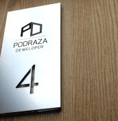 tabliczka z numerem mieszkania i grawerowanym logo