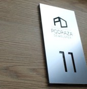 tabliczka z numerem mieszkania i grawerowanym logo